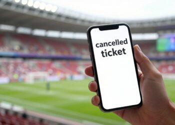 Fan with cancelled FIFA World Cup ticket on phone.
