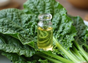 Leafy greens and a vial of vitamin B12 supplement.